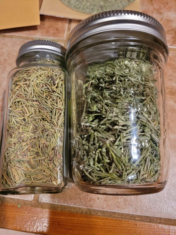 Two jars of herbs are sitting on the floor.