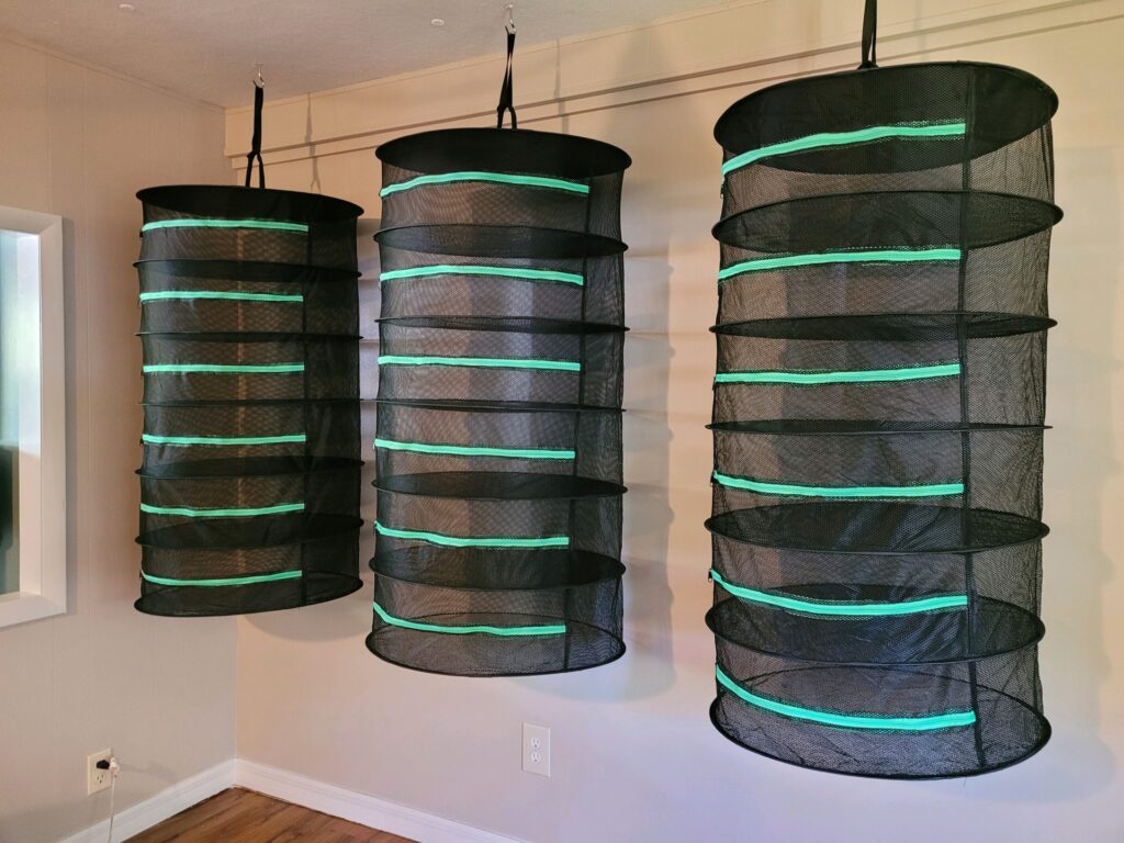 Three hanging mesh bags with green lights on them.